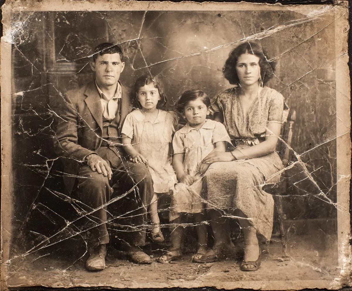 Old, cracked black-and-white family photo before AI restoration