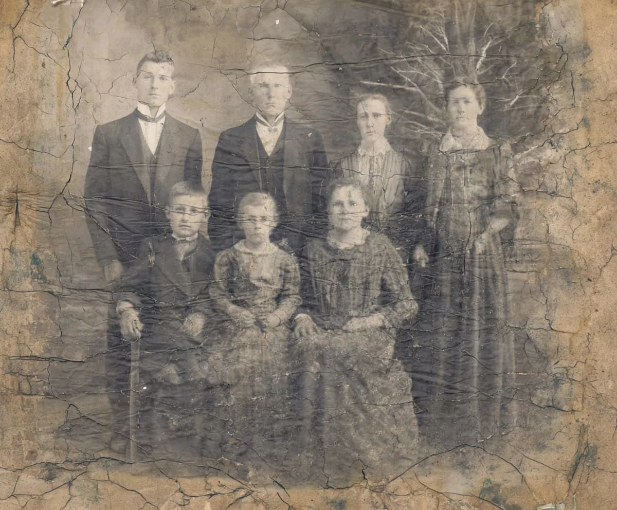 Vecchia foto di famiglia sbiadita e virata di colore prima del restauro con IA