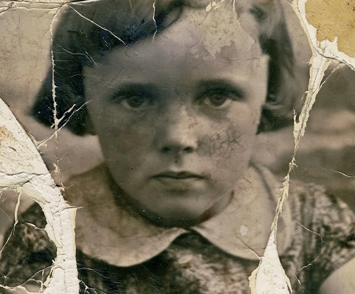 Black-and-white photo of a young child before AI restoration